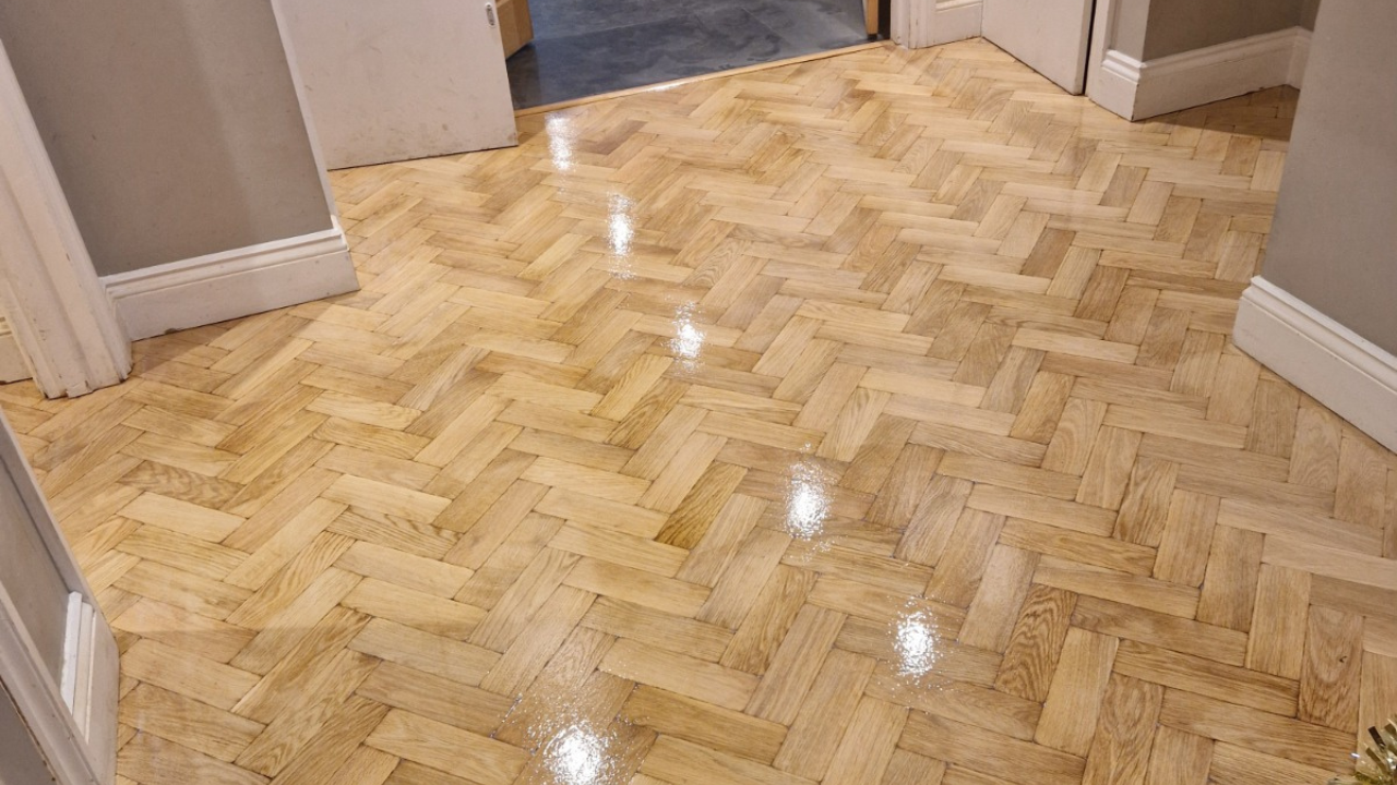 Wood Floor Sanding in West Brompton hallway on light oak herringbone parquet flooring, freshly sanded and lacquered to a glossy finish.