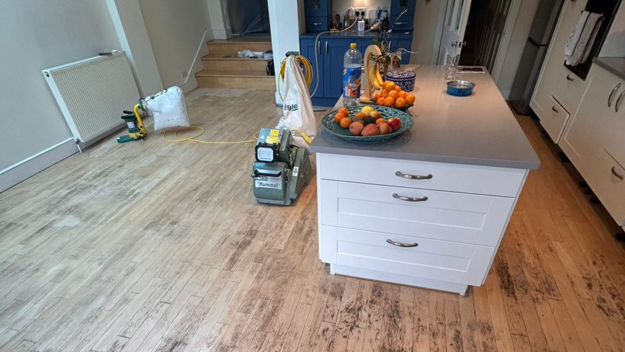 Hardwood Floor Sanding in West Brompton on a worn oak hardwood kitchen floor, showing professional sanding machines ready to restore the boards.